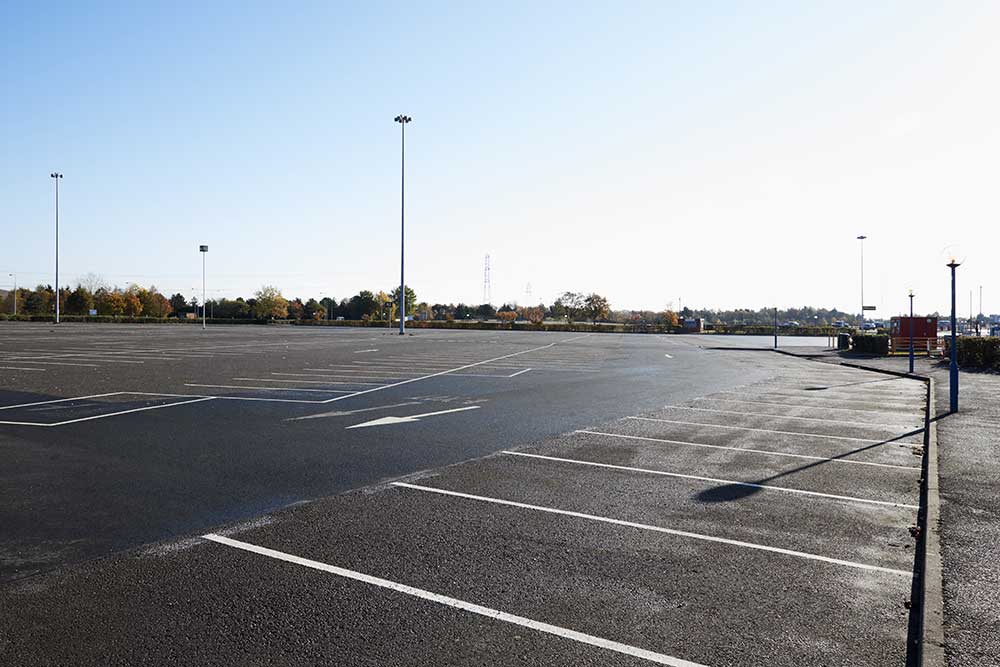A brand new commercial parking lot with marked spaces.