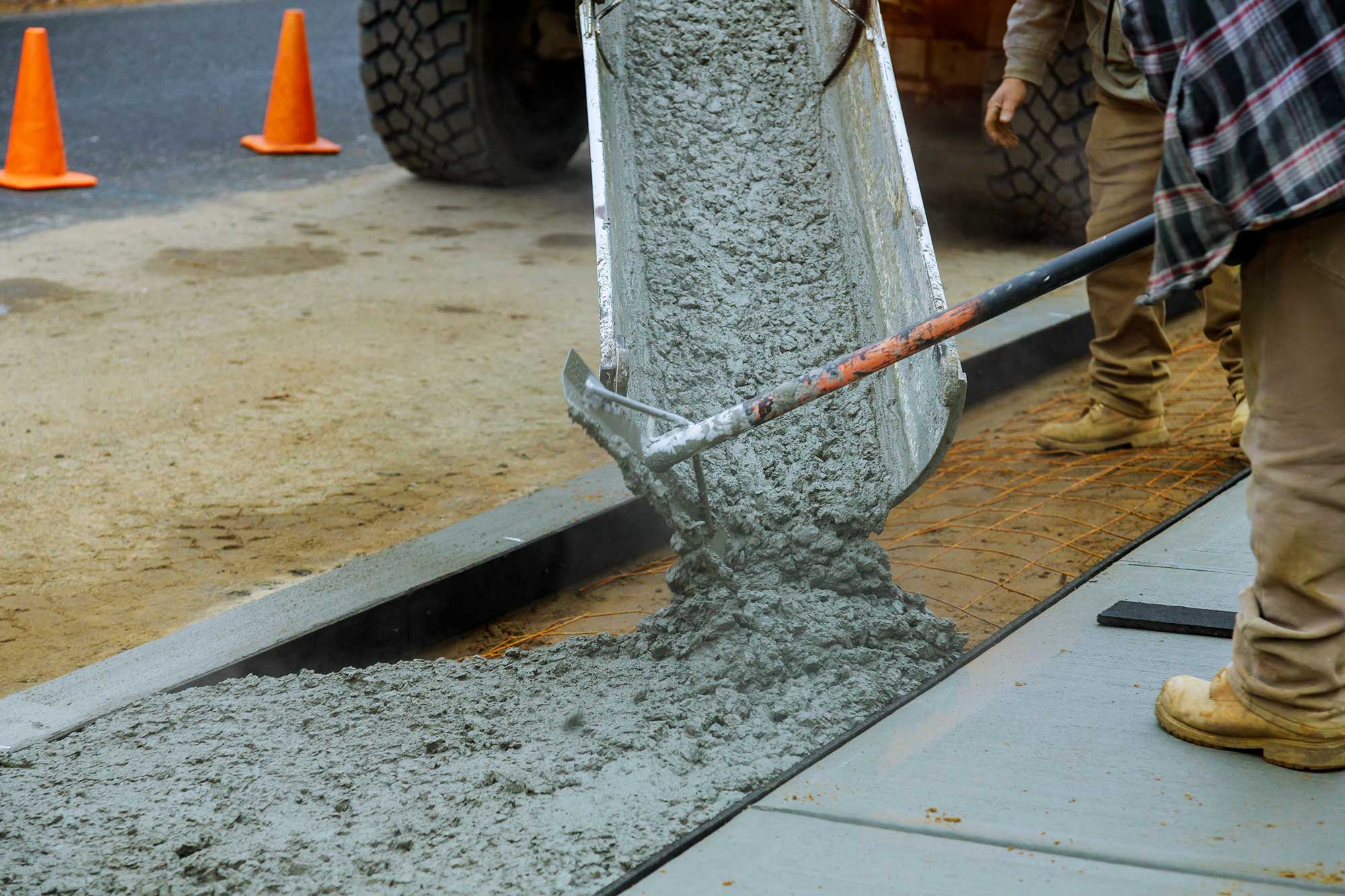 Workers pouring and leveling fresh concrete for a new sidewalk installation in Dickson, TN